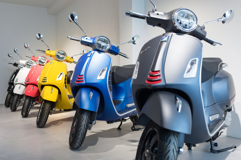 Various Vespa vehicles lined up in a row